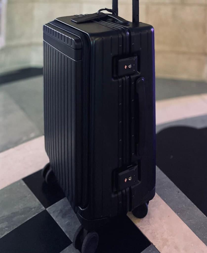 A side view of a black carry-onX roller bag with the two locks visible.