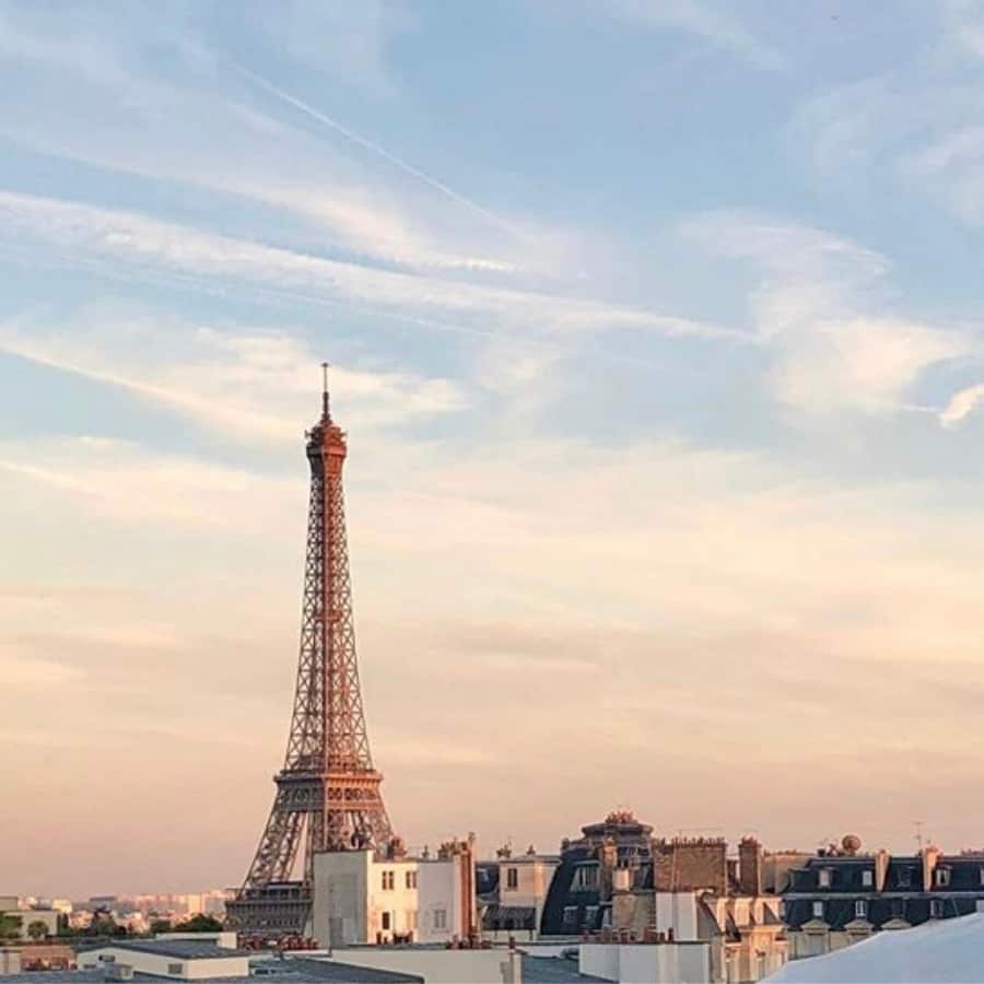 view of the eiffel tower among the rooftops, from the peninsula hotel paris