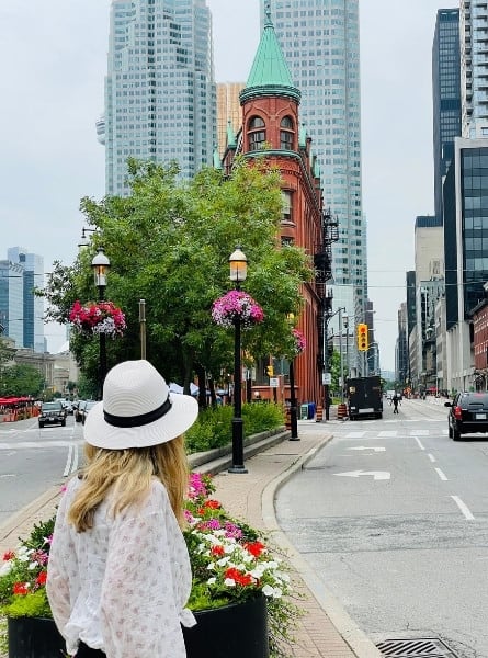 Susan Heinrich stands looking at Toronto's flatiron building, the Gooderham building completed in 1892