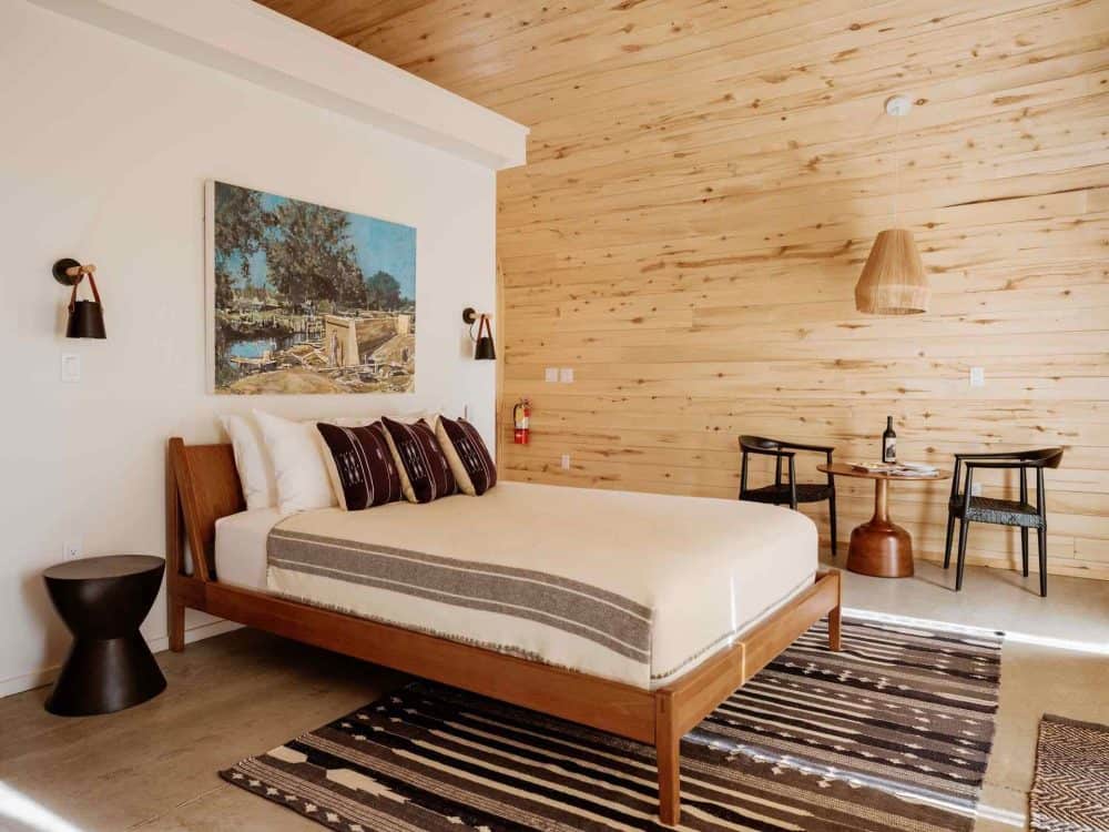 A nice hotel room in wood tones with a carpet and western decor