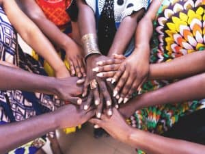 Women's hands of different colours are intertwined