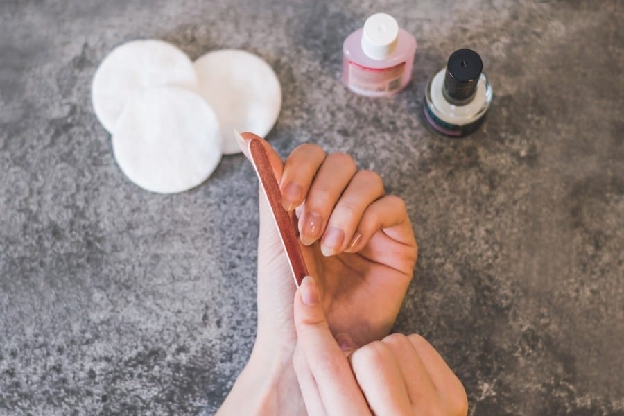 A woman gives herself a manicure