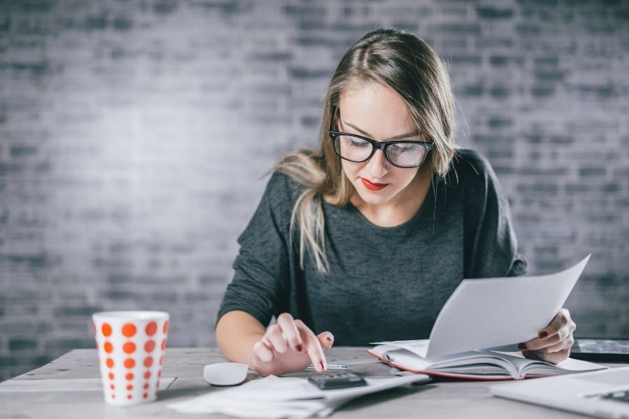 A woman uses a calculator to budget for a dream holiday