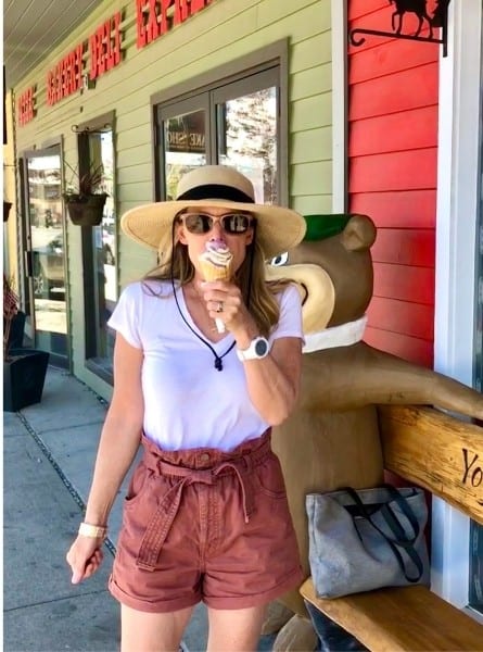 A woman is eating huckleberry ice cream in West Yellowstone