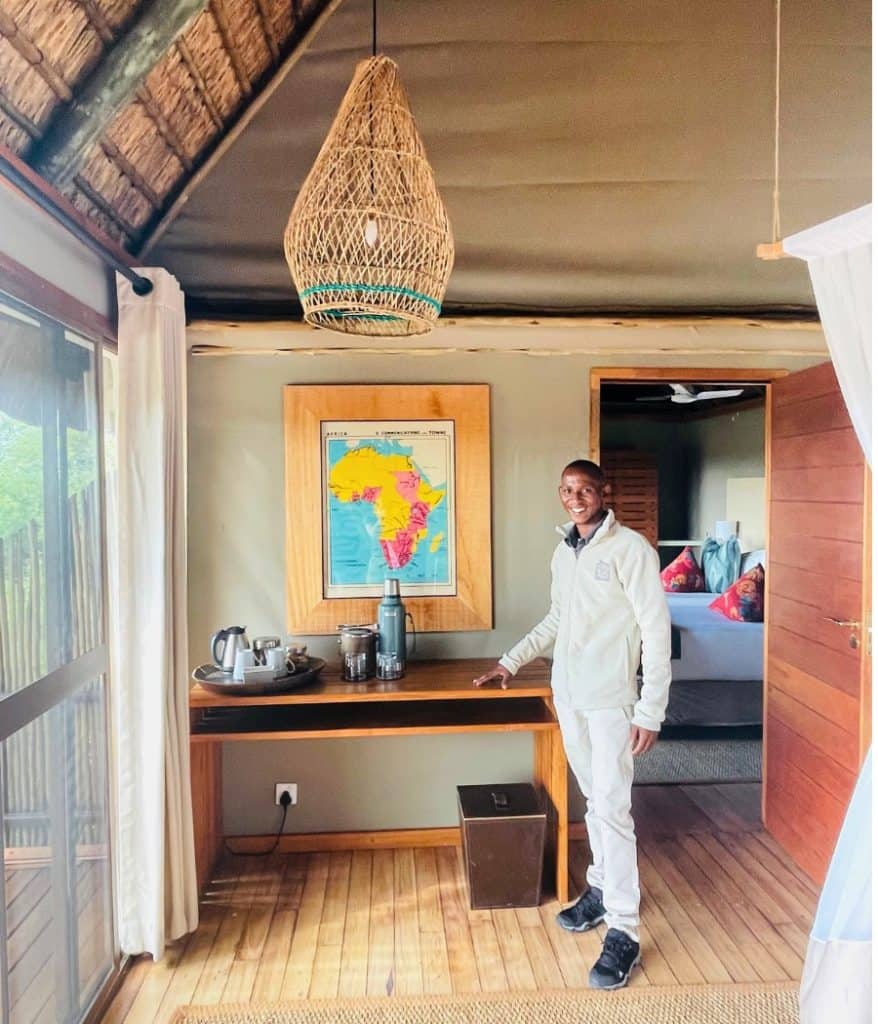 The family room at Leroo La Tau safari lodge. With camp manager Lesh standing next to a table with a map of Africa behind.