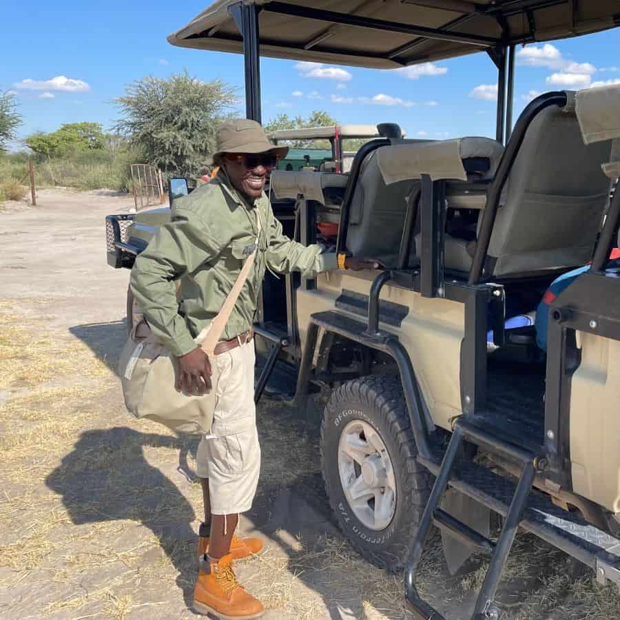 Leroo La Tau safari guide, DR, stands next to a safari jeep in Botswana