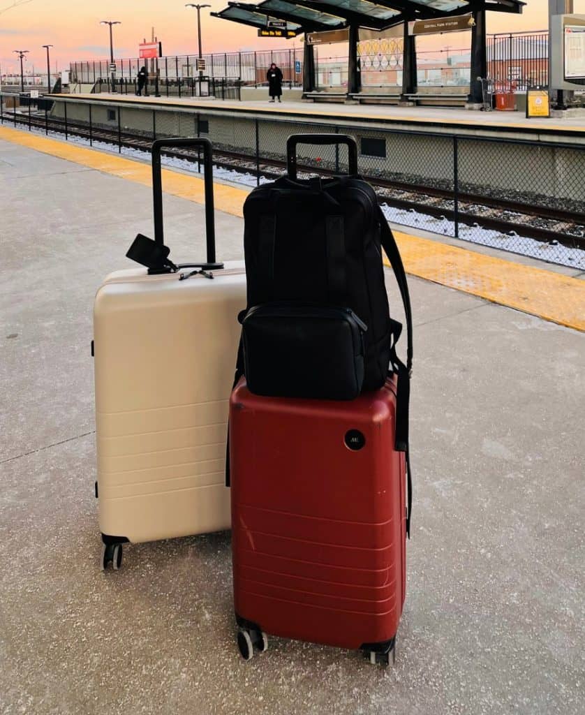 Monos luggage on a train platform at sunset