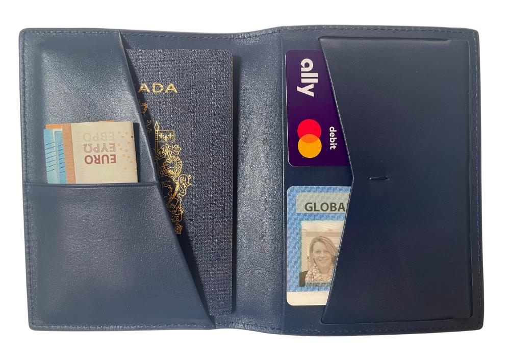 A blue passport wallet is pictured open with multiple pockets.Inside is a passport some euros and two cards: a bank card and an identity card.