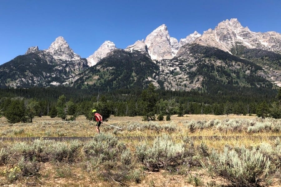 A roller blader on the bike path with the grand teton mountains beyond