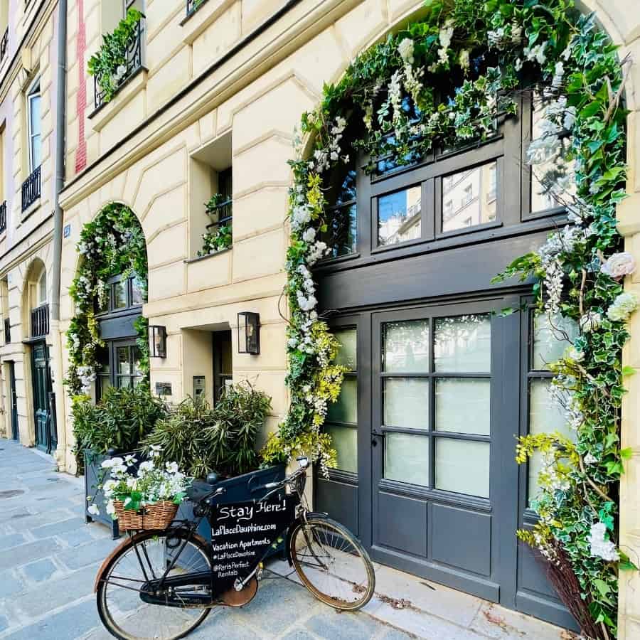 The charming entrance to a building in Place Dauphine in Paris with a sign advertising holiday apartments