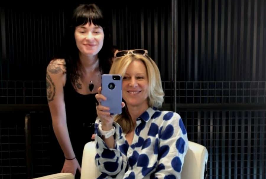 A woman sits in a hair salon with her stylist