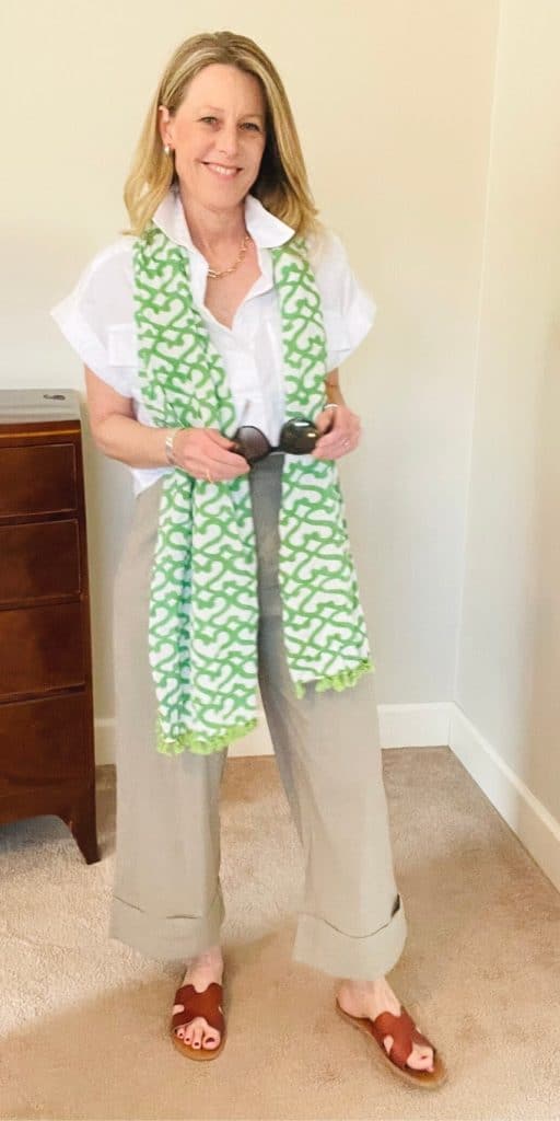 Susan in trousers, a white shirt and green patterned scarf