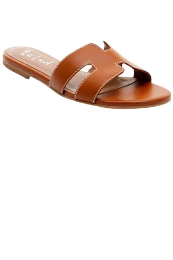 A flat slide-style sandal in a chestnut color, resembles the classic sandal by Hermes