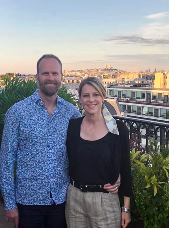 Susan Heinrich and her husband Sean stand together on the rooftop of the Mandarin Oriental Hotel in Paris.