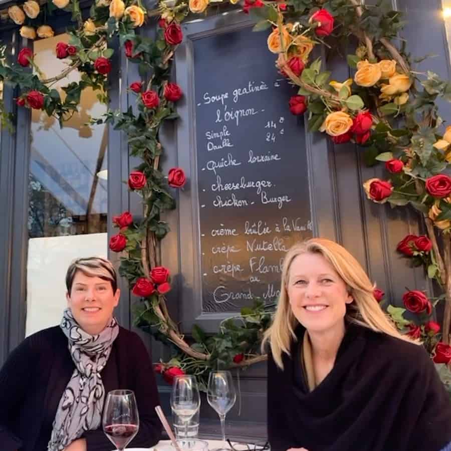 Susan Heinrich sits with a friend on the terrace at La Rose de France restaurant in Paris.