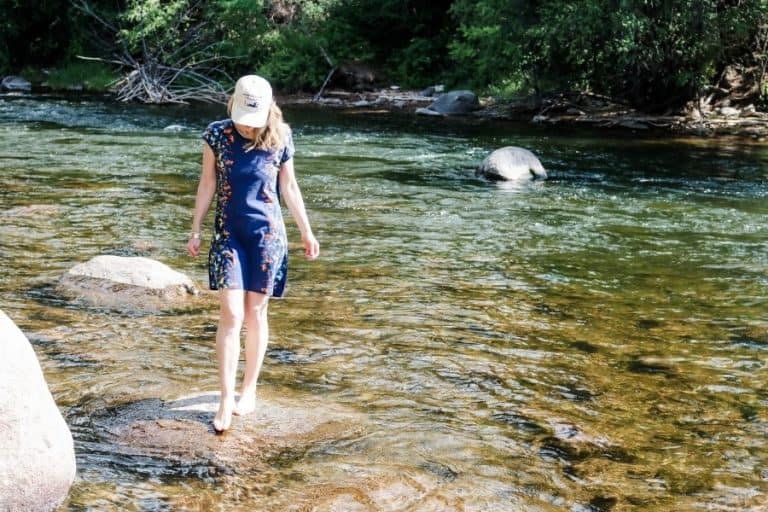 Susan Heinrich stands on a rock in a river in Beaver Creek Colorado