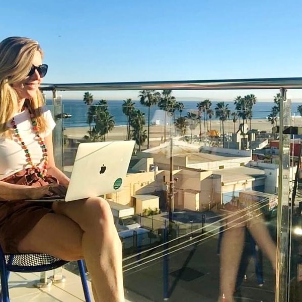susan-heinrich-writer-midlife-blog Susan Heinrich sits typing on a laptop and overlooking the Pacific Coast in L.A.