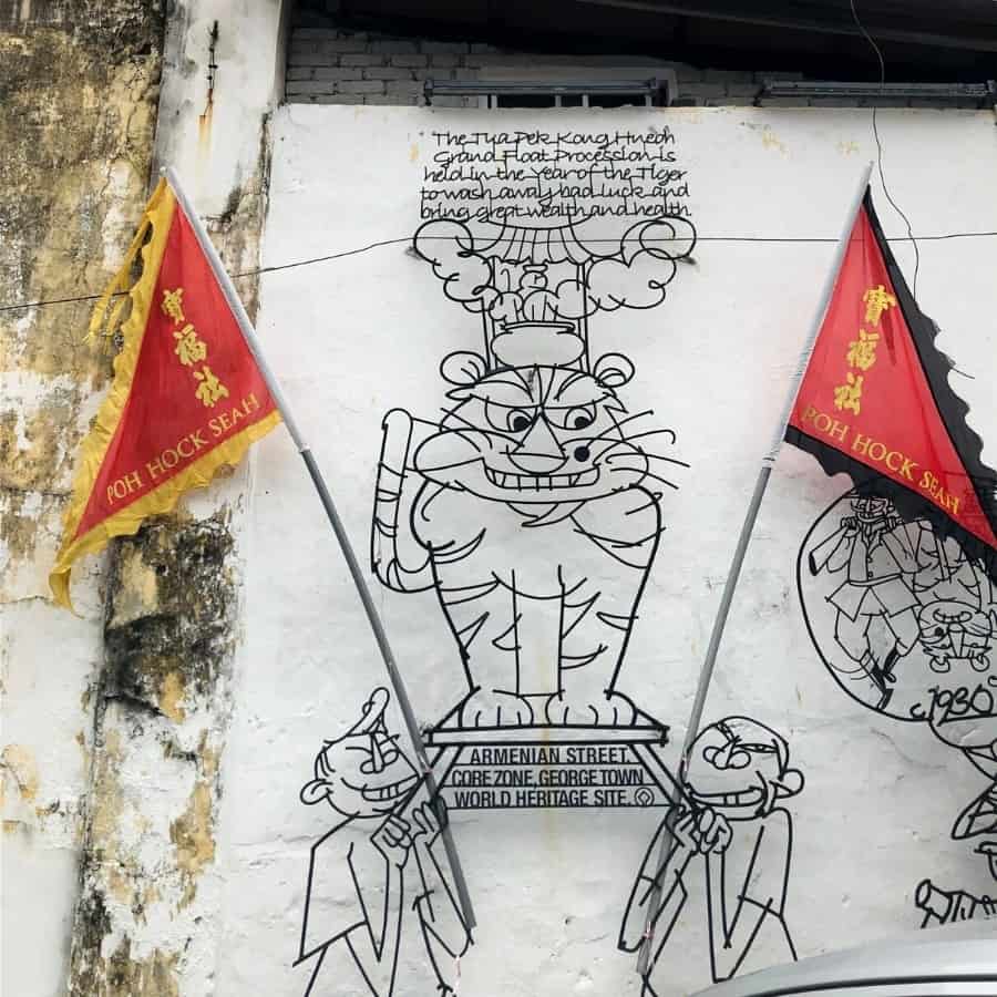 The Procession depicts a tiger sitting atop a procession float with flags on either side