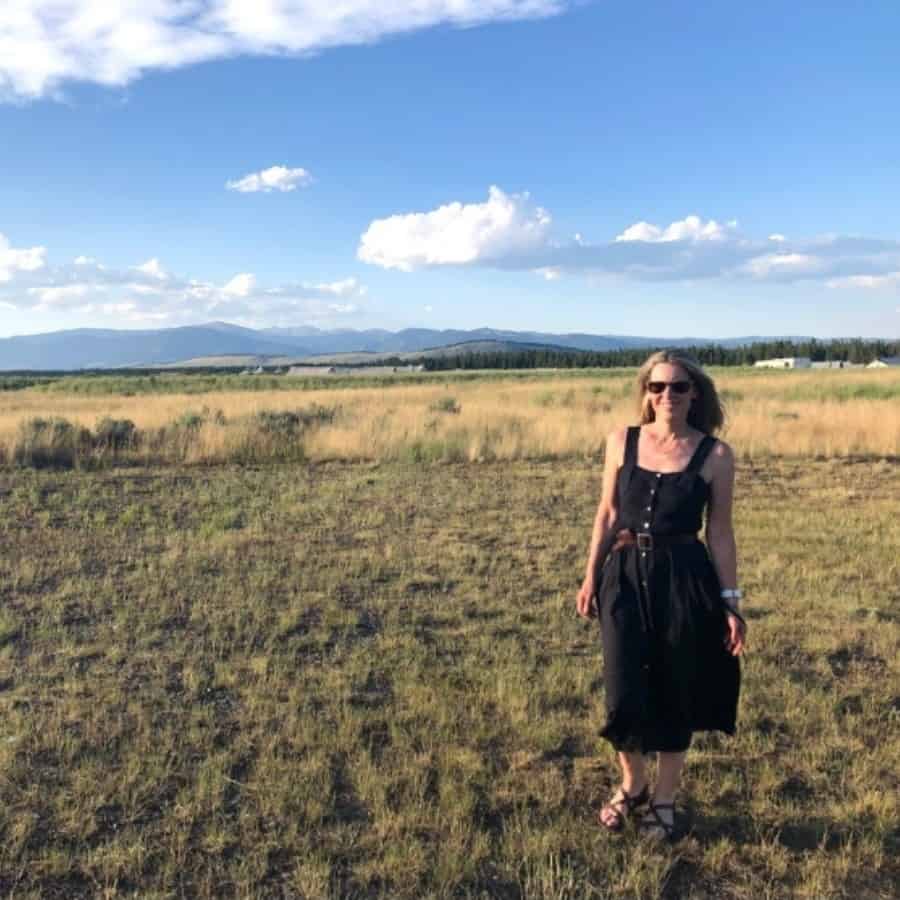 A woman walks in a field at Under Canvas Yellowstone